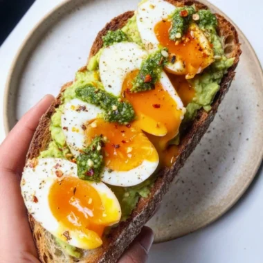 Avocado Pesto Toast topped with eggs on a plate