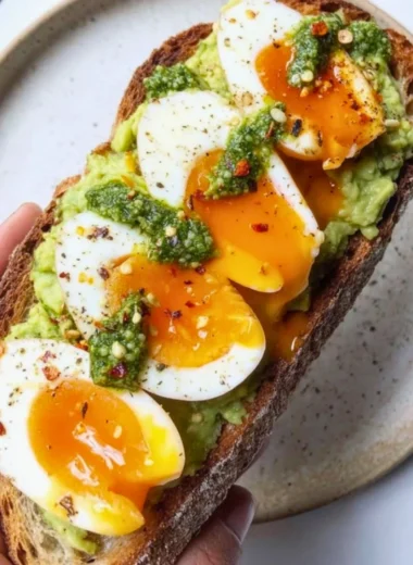 Avocado Pesto Toast topped with eggs on a plate