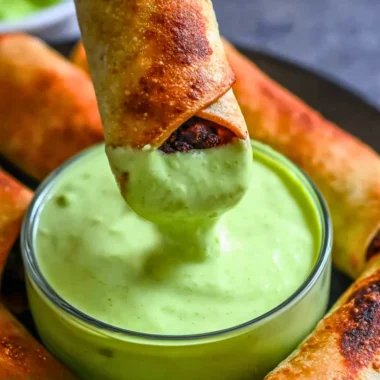 Baked black bean taquitos served with salsa and avocado