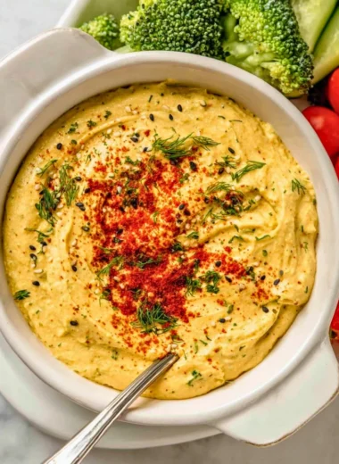 Delicious deviled egg dip served in a bowl with fresh herbs and crackers
