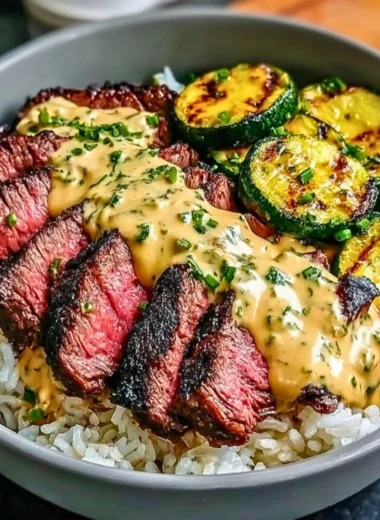 Delicious grilled steak bowl topped with sauce and grilled zucchini on a plate