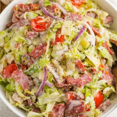 A colorful Italian Grinder Salad topped with fresh ingredients and dressing.