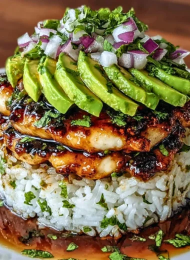 An enticing plate of Honey Lime Chicken and avocado rice stack garnished with lime.