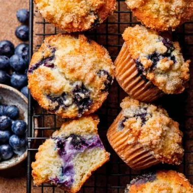Freshly baked bakery style blueberry muffins on a cooling rack