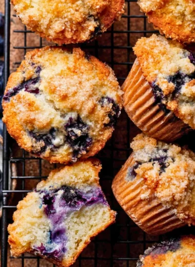 Freshly baked bakery style blueberry muffins on a cooling rack