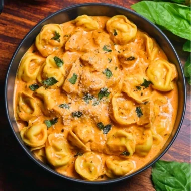 CrockPot Chicken Tortellini served in a bowl with fresh herbs