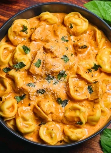CrockPot Chicken Tortellini served in a bowl with fresh herbs