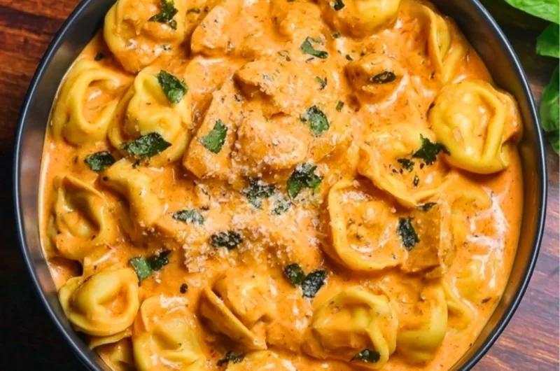 CrockPot Chicken Tortellini served in a bowl with fresh herbs
