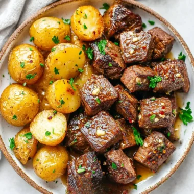 Garlic steak bites served with golden roasted potatoes on a plate