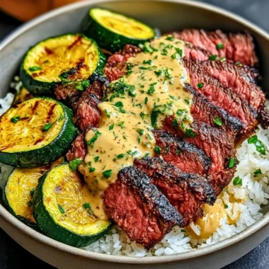 Delicious grilled steak bowl with sauce and grilled zucchini on a plate.