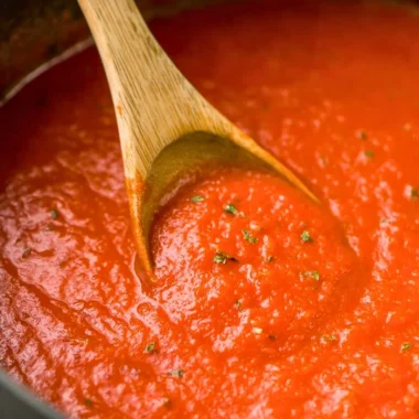 Bowl of homemade marinara sauce with fresh basil and tomatoes