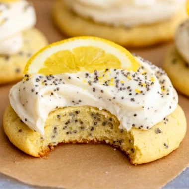 Lemon poppy seed cookies topped with cheesecake frosting on a plate