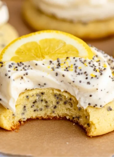Lemon poppy seed cookies topped with cheesecake frosting on a plate