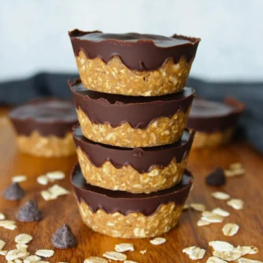 No bake peanut butter oat cups topped with chocolate and nuts.