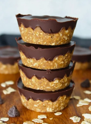 No bake peanut butter oat cups topped with chocolate and nuts.