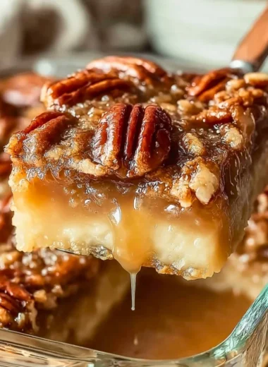 Delicious pecan pie dump cake displayed on a rustic wooden table.