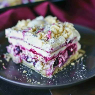 Delicious Blueberry Cream Cheesecake Lasagna slice with fresh blueberries on top