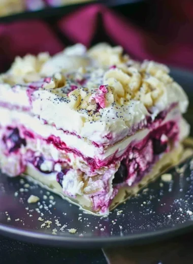 Delicious Blueberry Cream Cheesecake Lasagna slice with fresh blueberries on top