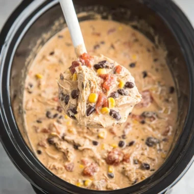 Bowl of creamy Crockpot White Chicken Chili topped with herbs and cheese