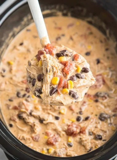 Bowl of creamy Crockpot White Chicken Chili topped with herbs and cheese