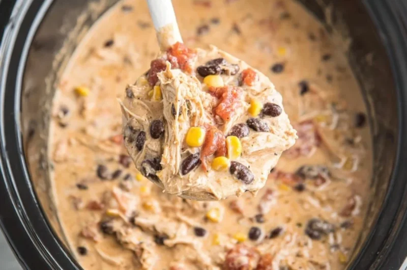 Bowl of creamy Crockpot White Chicken Chili topped with herbs and cheese