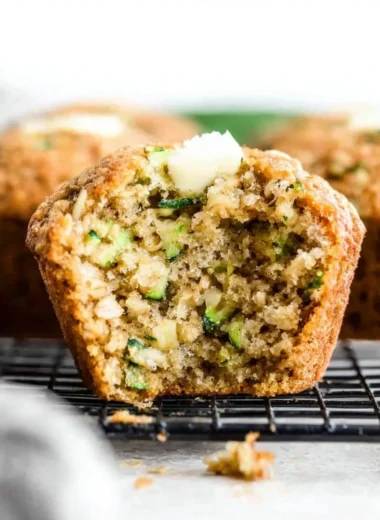 Freshly baked gluten-free zucchini muffins on a wooden table.