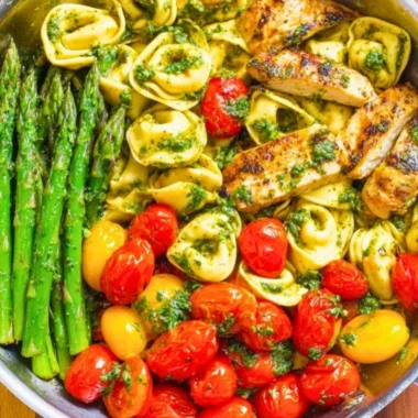 One-Pan Pesto Chicken with tortellini and colorful veggies for a quick meal.