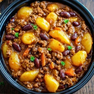 Delicious Slow Cooker Cowboy Casserole with beef, beans, and cheese in a bowl