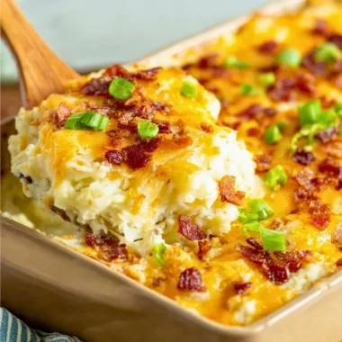 Delicious twice baked potato casserole from The Pioneer Woman topped with cheese.