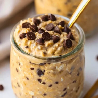 Bowl of cookie dough overnight oats topped with chocolate chips and nuts
