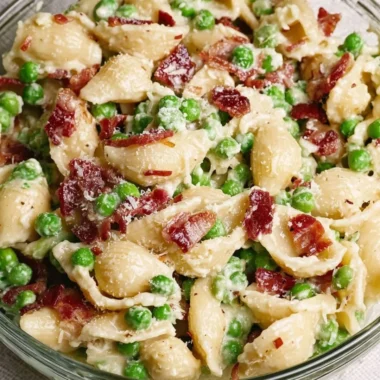 Creamy pea bacon pasta salad served in a bowl with fresh ingredients.