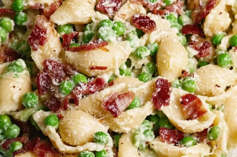 Creamy pea bacon pasta salad served in a bowl with fresh ingredients.