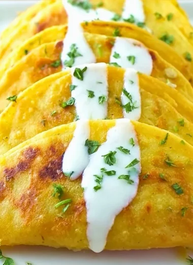 Plate of crispy potato tacos topped with fresh ingredients.