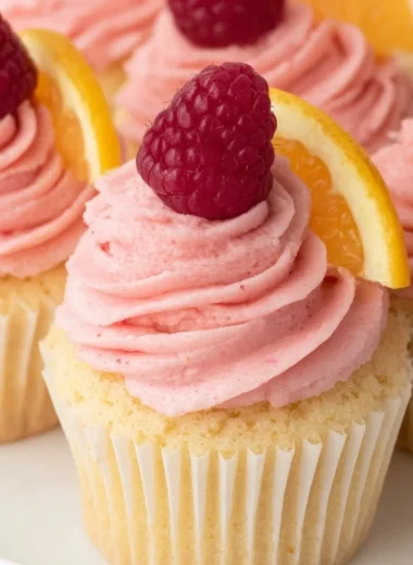 Lemon cupcakes decorated with raspberry buttercream frosting on a plate