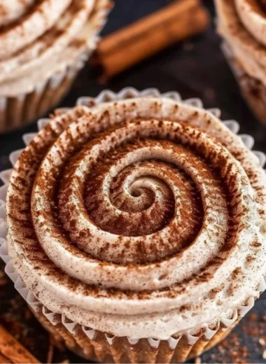 Mini No Bake Cinnamon Roll Cheesecakes topped with cinnamon and whipped cream