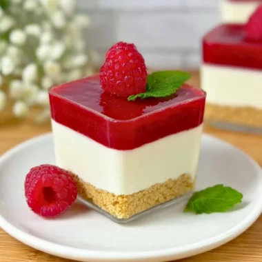 Delicious Raspberry Cheesecake layered in a glass with fresh raspberries