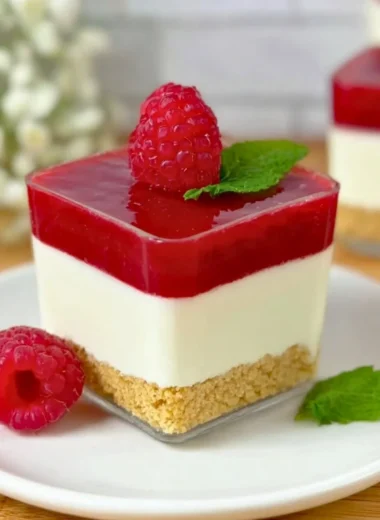 Delicious Raspberry Cheesecake layered in a glass with fresh raspberries