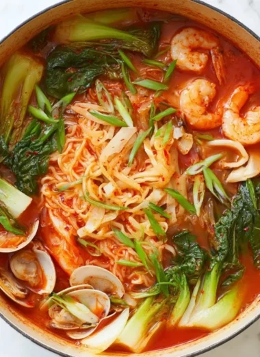 Bowl of spicy seafood noodle soup with fresh seafood and colorful vegetables