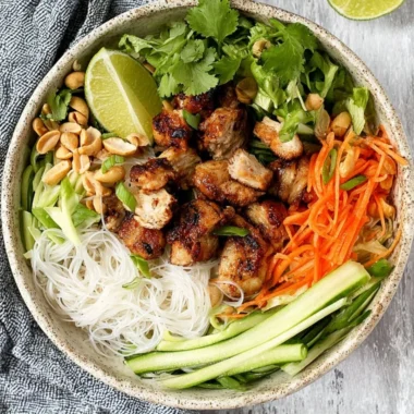 Vietnamese noodle bowl topped with lemongrass chicken and fresh herbs