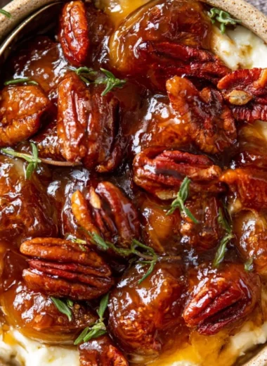 Baked feta dip served with fig jam and pecans in a rustic bowl