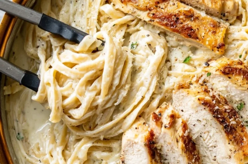 Creamy Chicken Fettuccine Alfredo served with fresh herbs and parmesan cheese